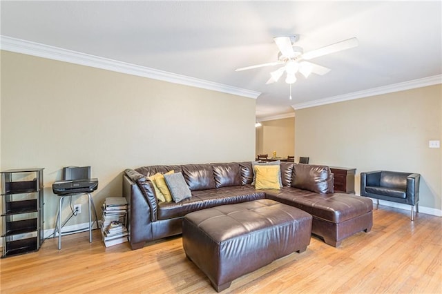 living room featuring baseboards, a ceiling fan, light wood-style flooring, and crown molding