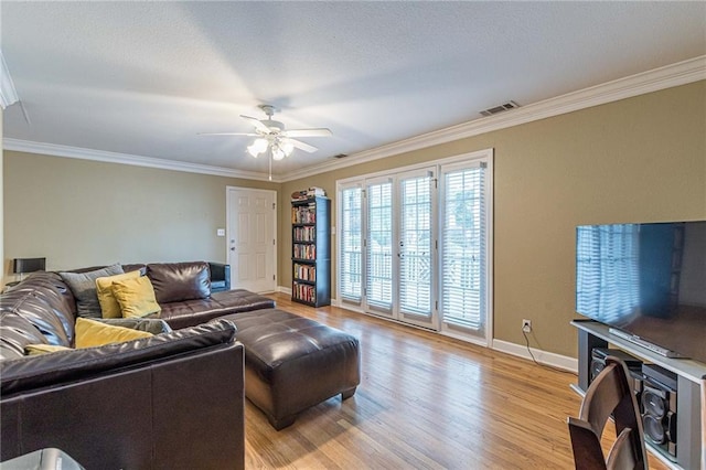 living area featuring visible vents, baseboards, light wood-style flooring, ceiling fan, and ornamental molding