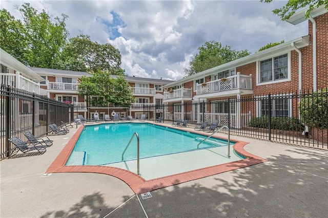 community pool featuring fence and a patio