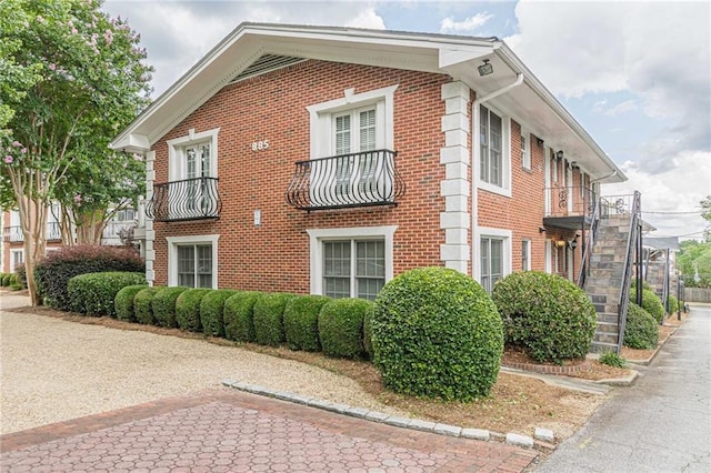 view of home's exterior featuring brick siding and a balcony