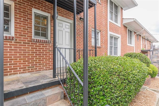 doorway to property featuring brick siding