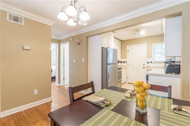 dining room featuring visible vents, an inviting chandelier, ornamental molding, light wood-type flooring, and baseboards