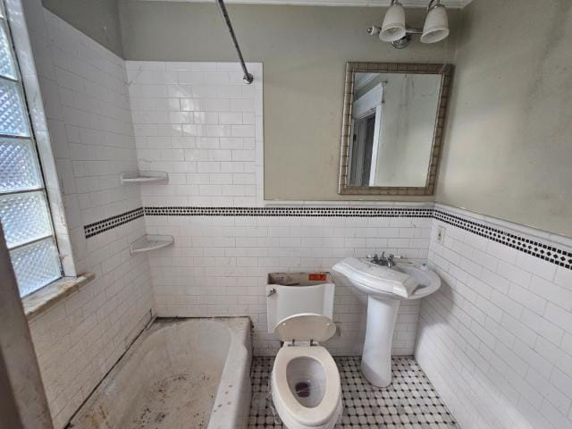 bathroom featuring tiled shower / bath, tile walls, toilet, and tile flooring