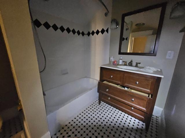 bathroom with tile floors, shower / tub combination, and large vanity