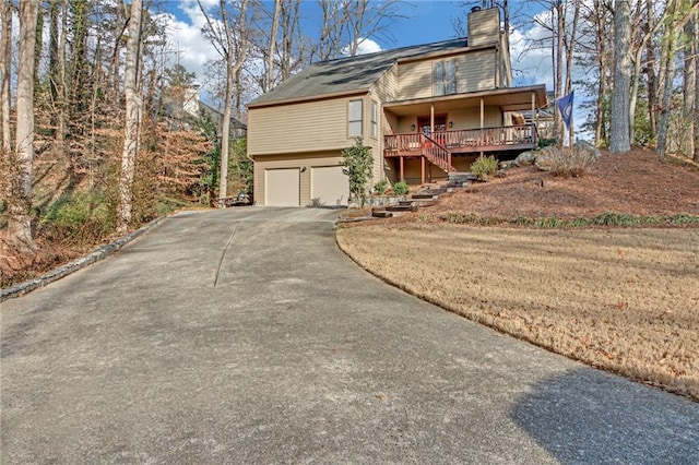 view of front of home with a garage, covered porch, and a front lawn