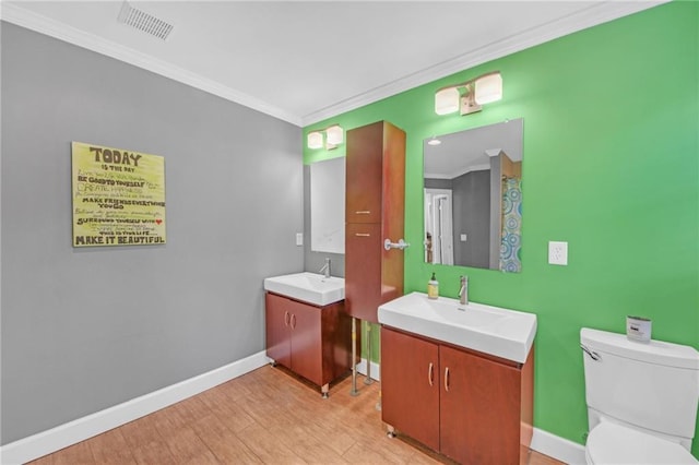 bathroom with vanity, hardwood / wood-style flooring, ornamental molding, and toilet