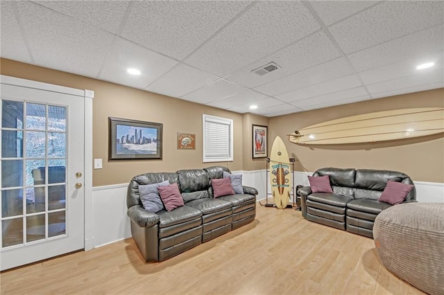 living room with a paneled ceiling and wood-type flooring