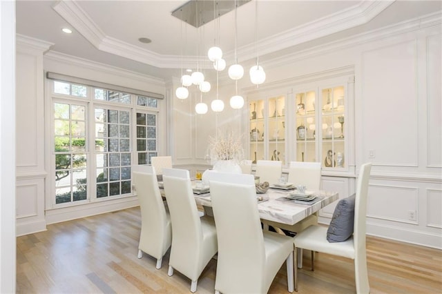 2461 Oak Grove Ests NE, Atlanta, GA 30345 - dining room featuring a decorative wall, light wood-type flooring, crown molding, and a raised ceiling