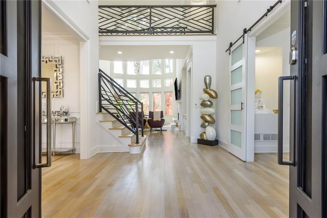 2461 Oak Grove Ests NE, Atlanta, GA 30345 - foyer entrance featuring a barn door, stairs, wood finished floors, and baseboards