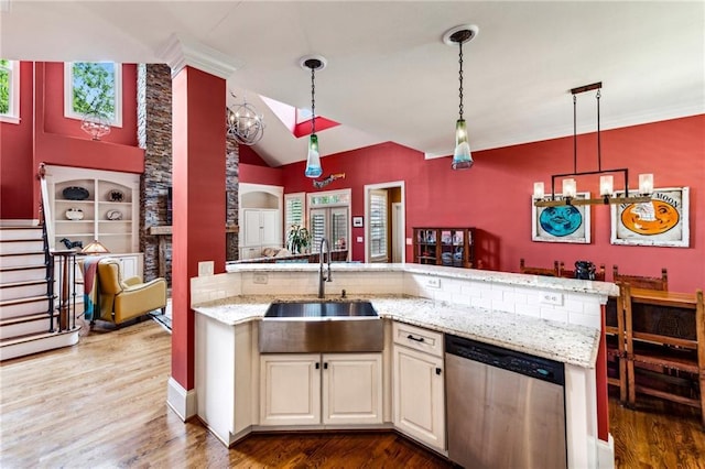 kitchen with stainless steel dishwasher, a sink, wood finished floors, hanging light fixtures, and lofted ceiling
