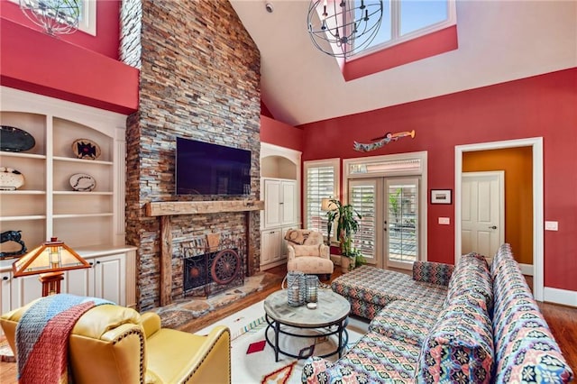 living area with wood finished floors, high vaulted ceiling, a fireplace, baseboards, and built in shelves