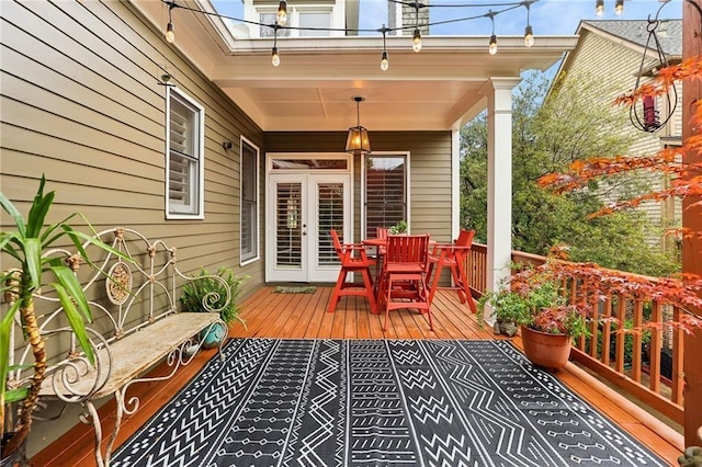 wooden terrace featuring french doors and outdoor dining space