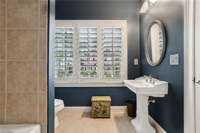 bathroom featuring tile patterned floors, baseboards, and toilet