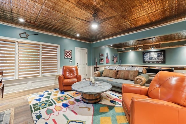 living room with an ornate ceiling, ornamental molding, wood finished floors, and a ceiling fan