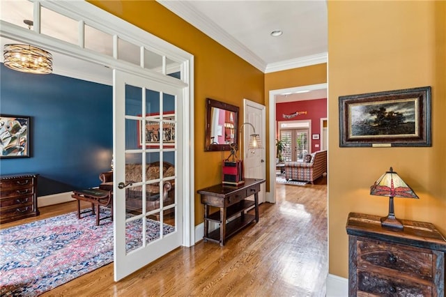 doorway to outside with french doors, wood finished floors, crown molding, and baseboards