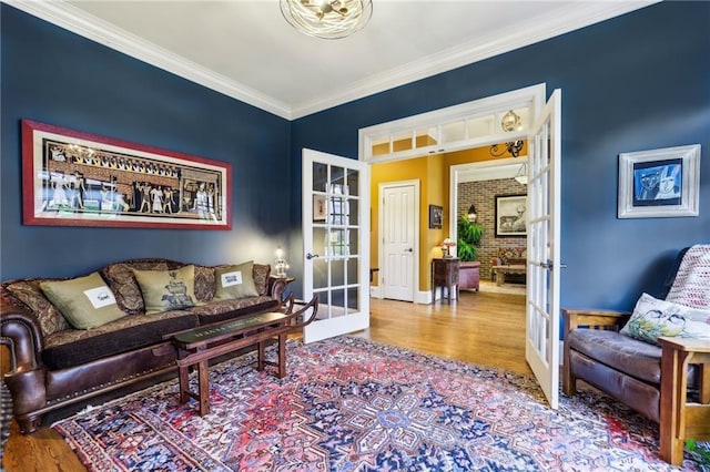 living area featuring french doors, wood finished floors, ornamental molding, and baseboards