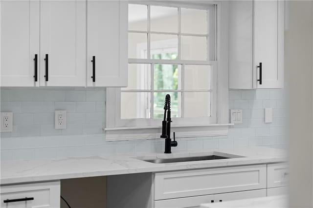 kitchen with white cabinetry and a sink