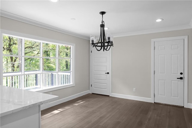 unfurnished dining area with dark wood-style floors, ornamental molding, a notable chandelier, and baseboards