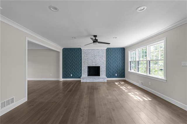 unfurnished living room featuring ornamental molding, visible vents, and a stone fireplace