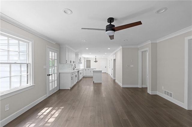 unfurnished living room featuring recessed lighting, visible vents, ornamental molding, dark wood-type flooring, and baseboards