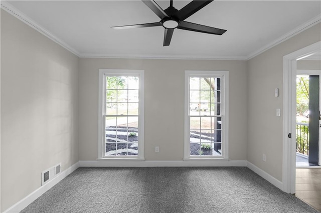 carpeted spare room with crown molding, visible vents, and plenty of natural light