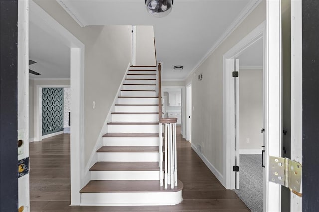 stairs featuring ornamental molding, wood finished floors, and baseboards