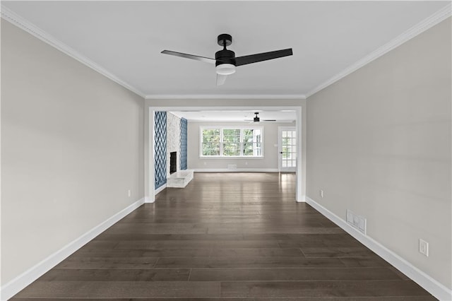 unfurnished living room with a fireplace with raised hearth, dark wood-type flooring, visible vents, baseboards, and crown molding