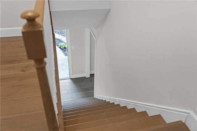 stairs with baseboards and wood finished floors