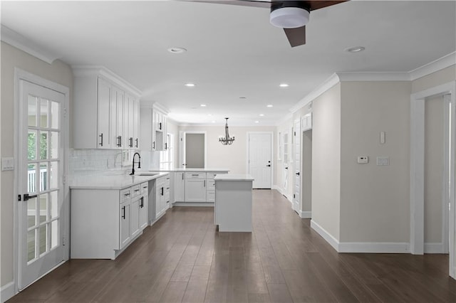 kitchen featuring a center island, white cabinets, light countertops, and hanging light fixtures