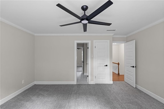 unfurnished bedroom featuring crown molding, visible vents, a ceiling fan, carpet flooring, and baseboards