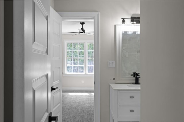 bathroom with ceiling fan, baseboards, and vanity