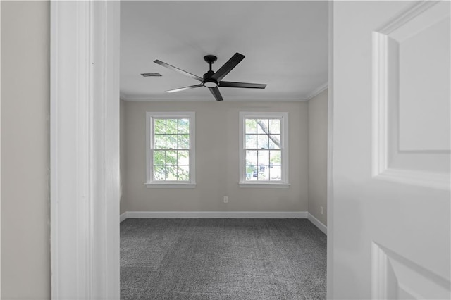 carpeted empty room with ornamental molding, visible vents, baseboards, and a ceiling fan