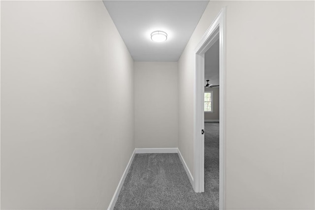 hallway featuring carpet floors and baseboards