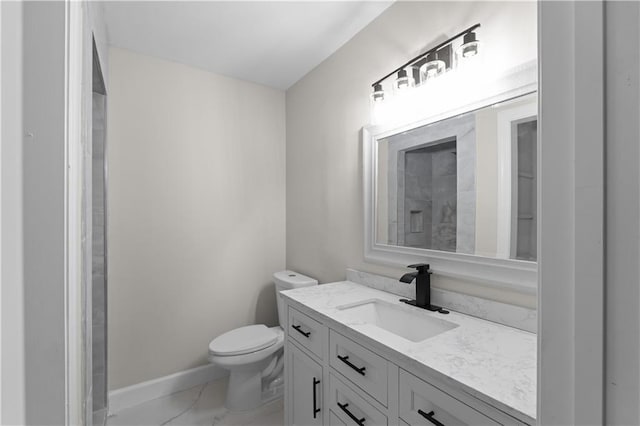 bathroom featuring toilet, marble finish floor, vanity, and baseboards