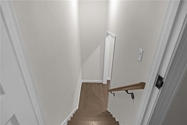 staircase with baseboards and wood finished floors