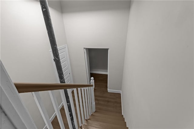 staircase with baseboards and wood finished floors