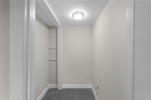 interior space with baseboards and dark colored carpet