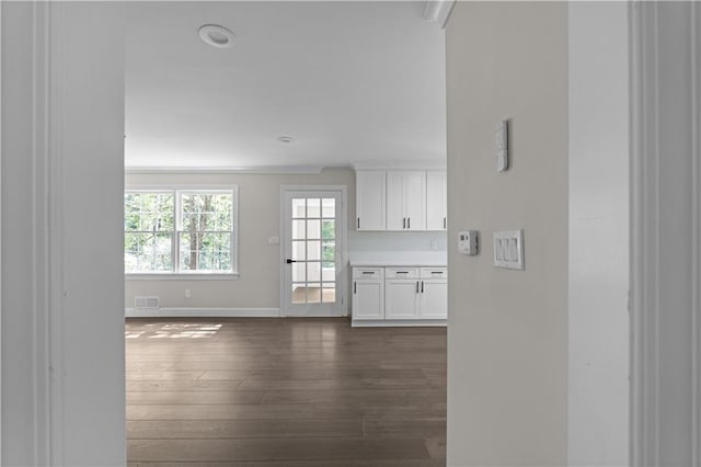 interior space featuring dark wood-type flooring, visible vents, and baseboards