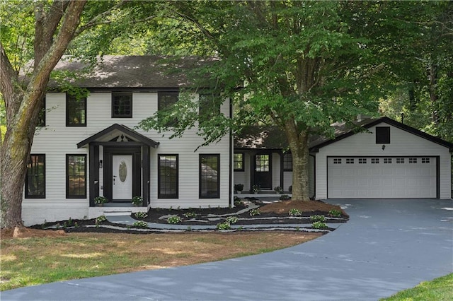 colonial inspired home featuring a garage and driveway