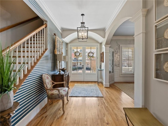 entryway featuring a notable chandelier, crown molding, french doors, and light wood-type flooring