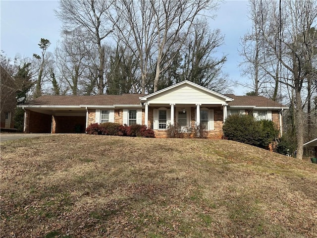 view of front of house with a carport, a porch, and a front lawn