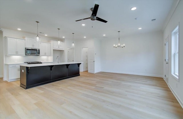 kitchen with white cabinetry, a large island, and hanging light fixtures