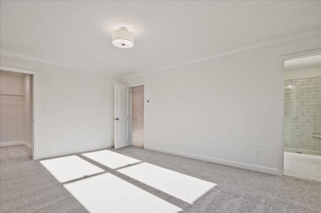 unfurnished bedroom featuring ensuite bathroom and light colored carpet