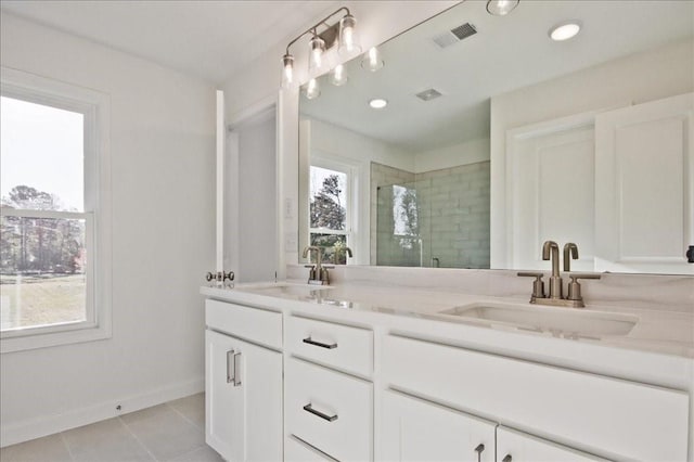 bathroom with tile patterned flooring, vanity, plenty of natural light, and an enclosed shower