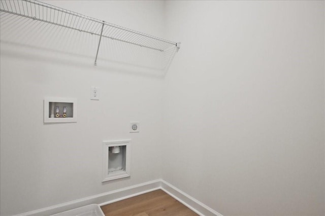 clothes washing area with electric dryer hookup, washer hookup, and hardwood / wood-style floors