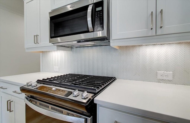 kitchen with hardwood / wood-style flooring, stainless steel appliances, decorative backsplash, and white cabinets