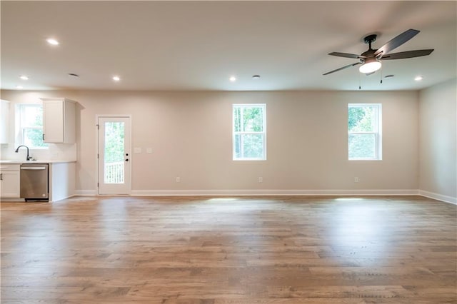 138 Henley St, Canton, GA 30114 - unfurnished living room featuring ceiling fan, light wood-type flooring, baseboards, recessed lighting, and a sink