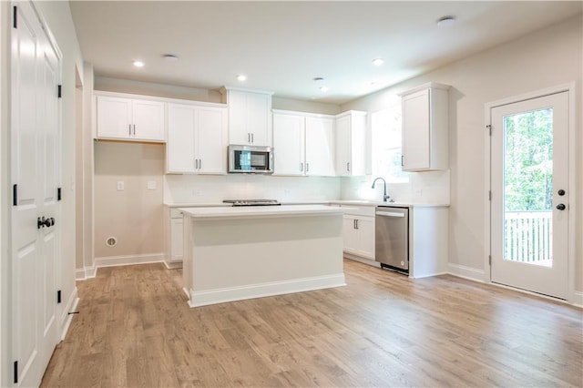 138 Henley St, Canton, GA 30114 - kitchen featuring appliances with stainless steel finishes, tasteful backsplash, light wood-style flooring, white cabinetry, and recessed lighting