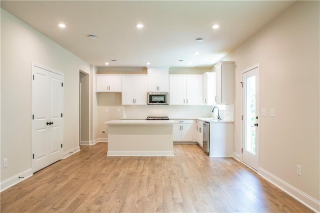 138 Henley St, Canton, GA 30114 - kitchen featuring stainless steel appliances, light wood-style floors, white cabinets, a kitchen island, and recessed lighting