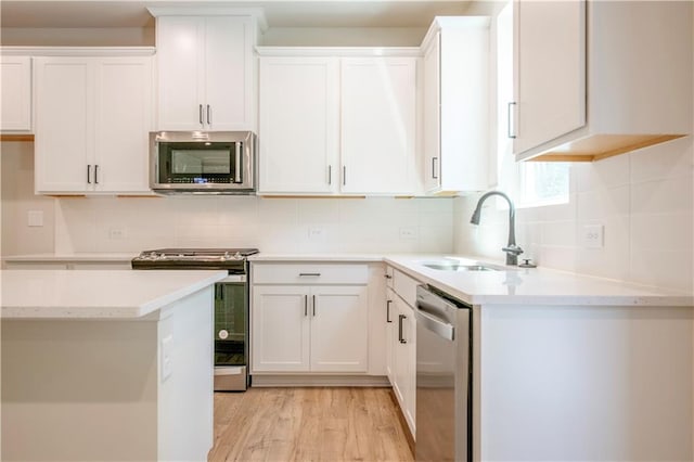138 Henley St, Canton, GA 30114 - kitchen featuring appliances with stainless steel finishes, a sink, white cabinetry, and decorative backsplash